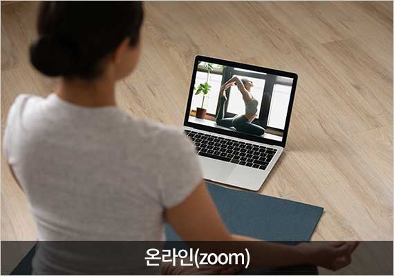 요가 수련생이 노트북 줌으로 요가하고 동작을 보고 있다